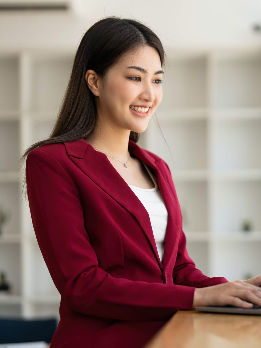 Charming Asian businesswoman sitting in the office with a digital laptop computer. Excited Asian